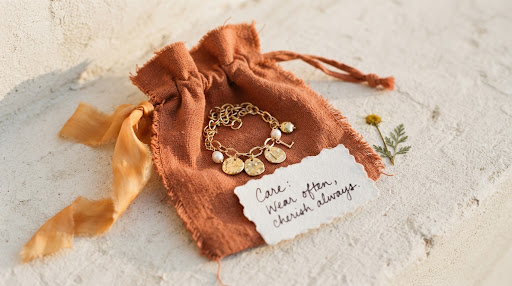 A charm bracelet in a warm terracotta keepsake pouch